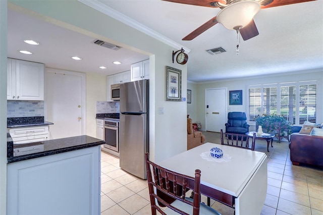 kitchen with decorative backsplash, appliances with stainless steel finishes, and white cabinetry