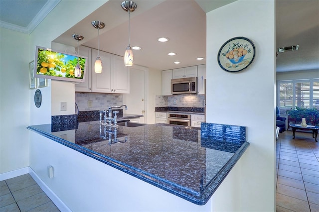 kitchen with white cabinets, sink, kitchen peninsula, and stainless steel appliances