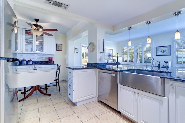 kitchen with dishwasher, dark stone counters, hanging light fixtures, light tile patterned floors, and white cabinetry