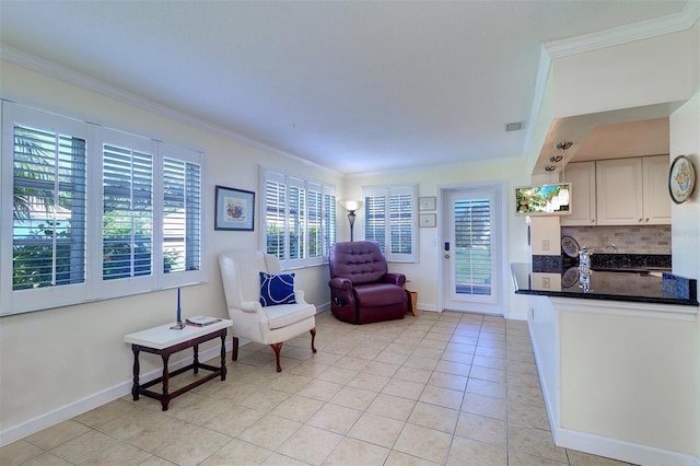 living area with plenty of natural light, sink, light tile patterned floors, and crown molding