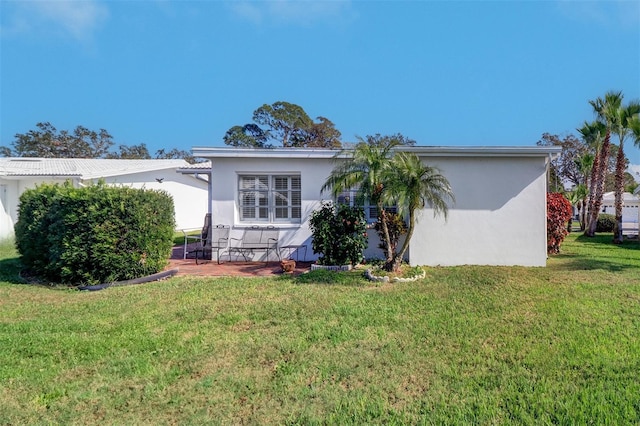 rear view of property featuring a yard and a patio area