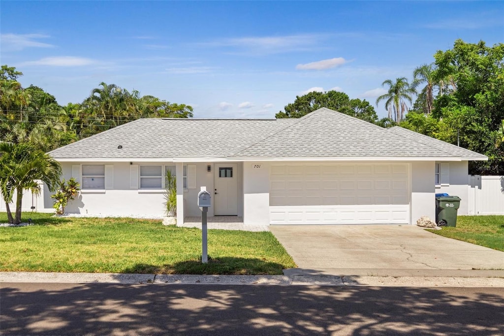 ranch-style home with a garage and a front yard