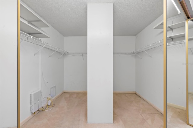 walk in closet featuring light colored carpet