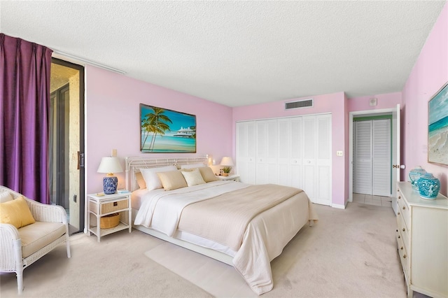 bedroom with light carpet and a textured ceiling