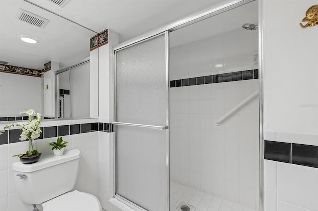 bathroom with a shower with door, toilet, and tile walls