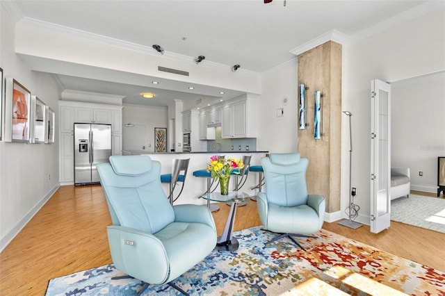 living room with light hardwood / wood-style flooring, ornamental molding, and sink