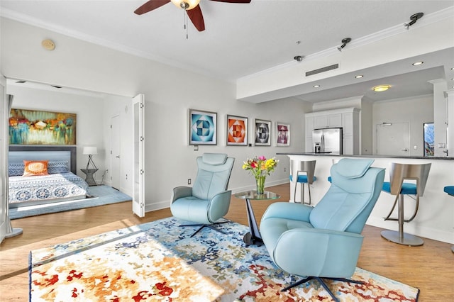 living area featuring ceiling fan, crown molding, and light hardwood / wood-style flooring