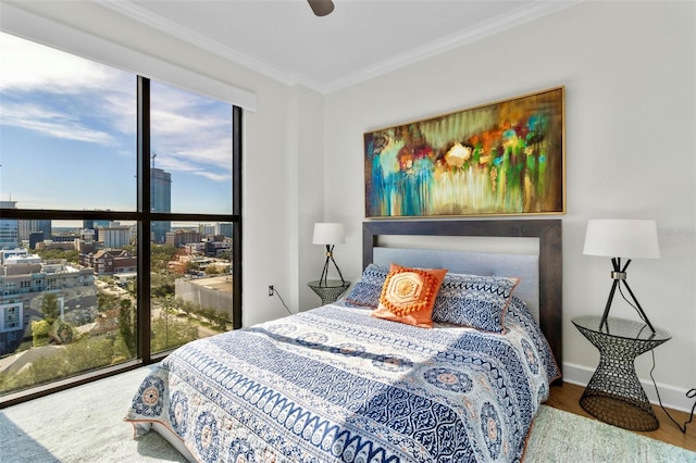 bedroom featuring wood finished floors, baseboards, and ornamental molding