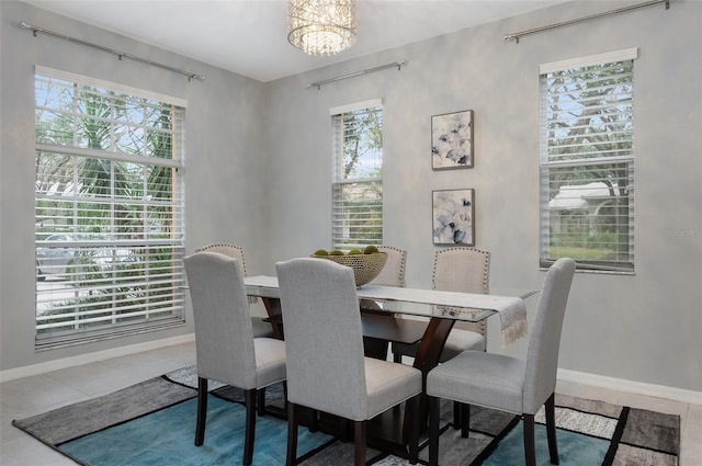 tiled dining space featuring a wealth of natural light and a chandelier