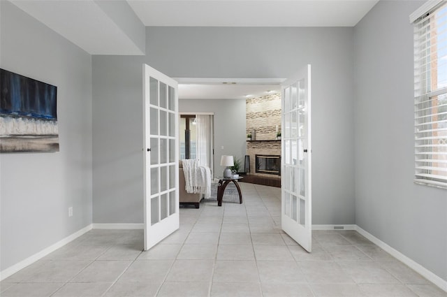 corridor with light tile patterned floors and french doors