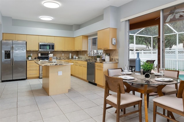 kitchen with tasteful backsplash, a center island, sink, appliances with stainless steel finishes, and light brown cabinets