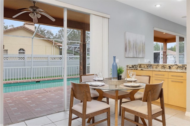 dining room featuring a wealth of natural light, light tile patterned floors, ceiling fan, and sink