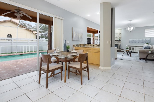 tiled dining space with ceiling fan with notable chandelier