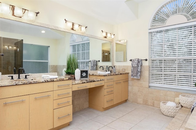 bathroom featuring an enclosed shower, tile patterned floors, vanity, plenty of natural light, and tile walls