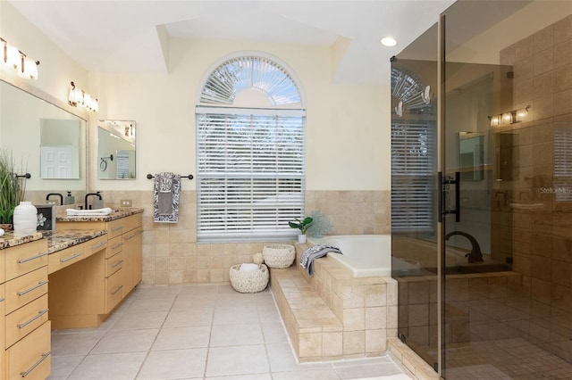 bathroom with vanity, tile patterned flooring, tile walls, and plus walk in shower