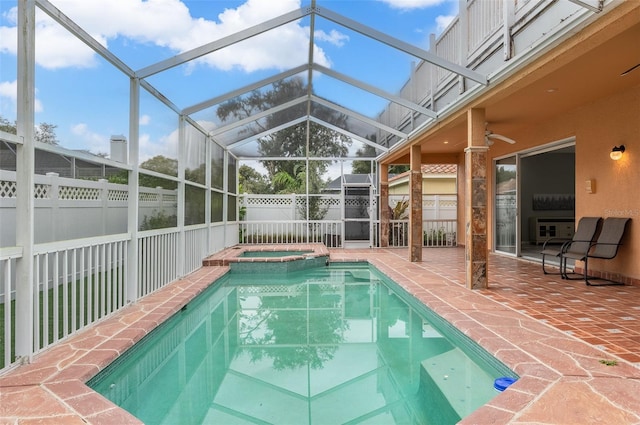 view of pool with ceiling fan, a patio area, glass enclosure, and an in ground hot tub