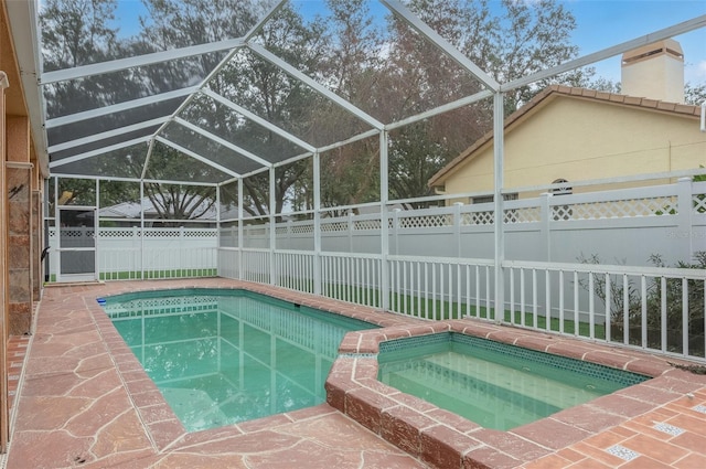 view of swimming pool with an in ground hot tub and a lanai