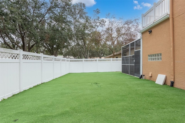 view of yard with a lanai and a balcony