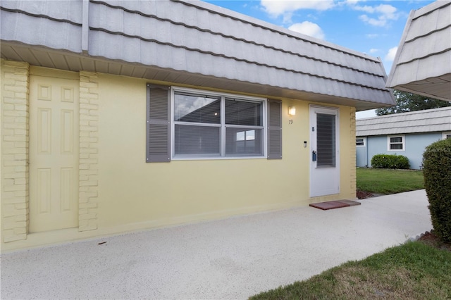 view of exterior entry with a yard