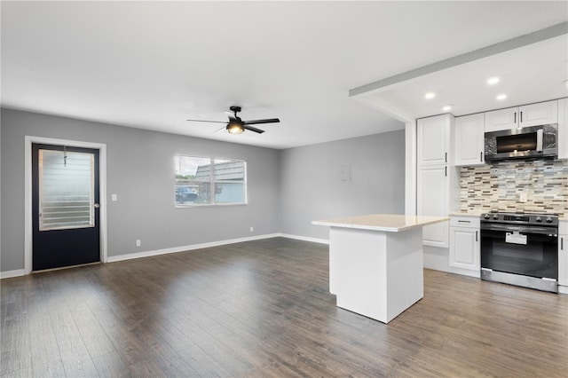 kitchen with white cabinets, decorative backsplash, range with electric stovetop, and a center island