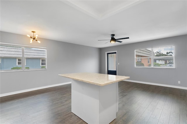 kitchen featuring ceiling fan with notable chandelier, white cabinets, a center island, dark hardwood / wood-style floors, and hanging light fixtures