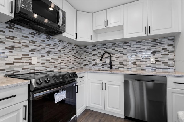 kitchen featuring sink, decorative backsplash, light stone counters, white cabinetry, and stainless steel appliances