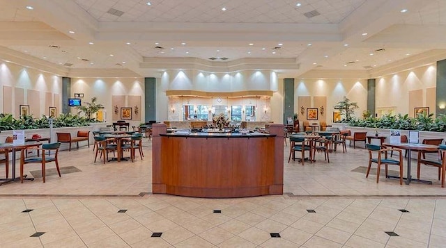 interior space with light tile patterned floors, a tray ceiling, and a high ceiling