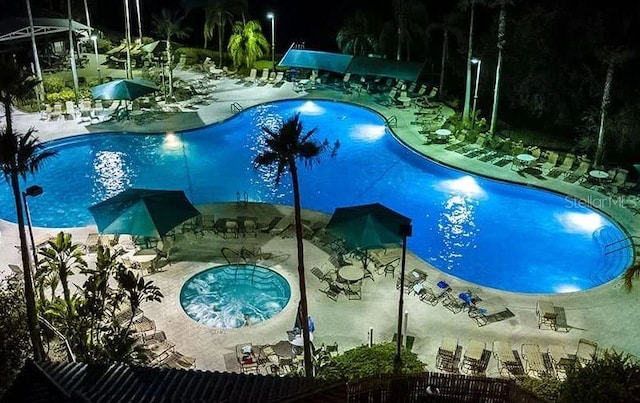 view of swimming pool featuring a community hot tub and a patio