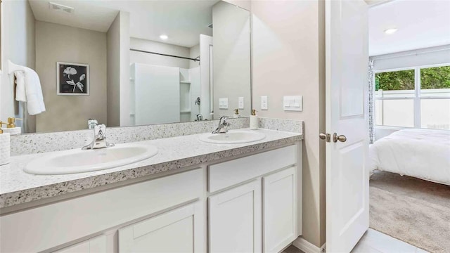 bathroom with tile patterned floors, vanity, and a shower