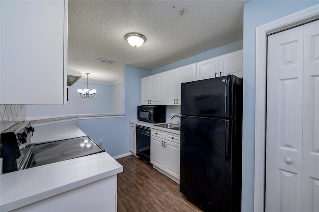 kitchen with black appliances, decorative light fixtures, and white cabinets