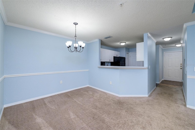 carpeted spare room with a chandelier, a textured ceiling, and ornamental molding