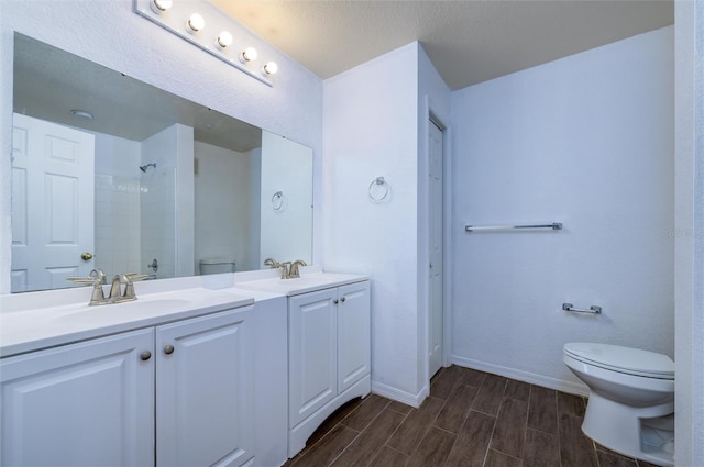 bathroom with vanity, toilet, and walk in shower