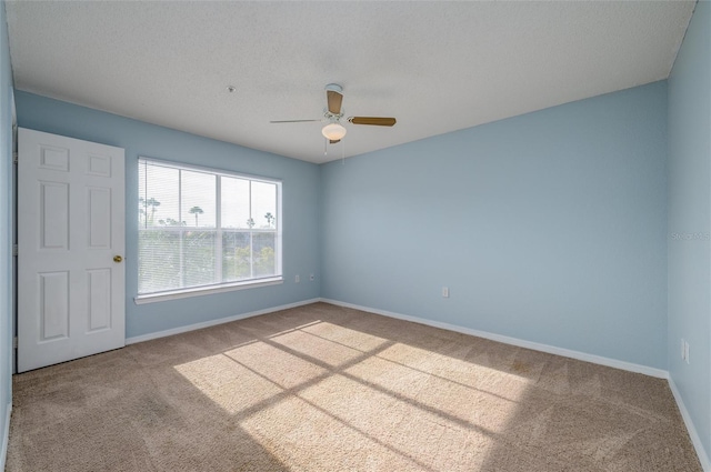 spare room featuring carpet flooring, ceiling fan, and a textured ceiling