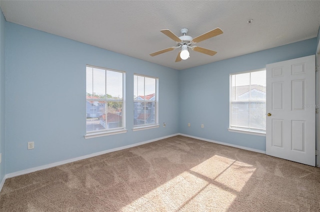 carpeted empty room featuring ceiling fan