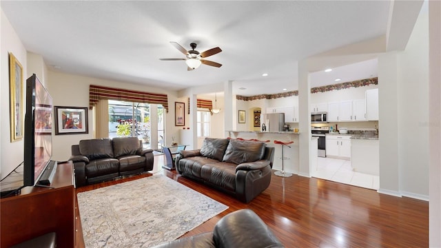 living room featuring ceiling fan and light hardwood / wood-style flooring