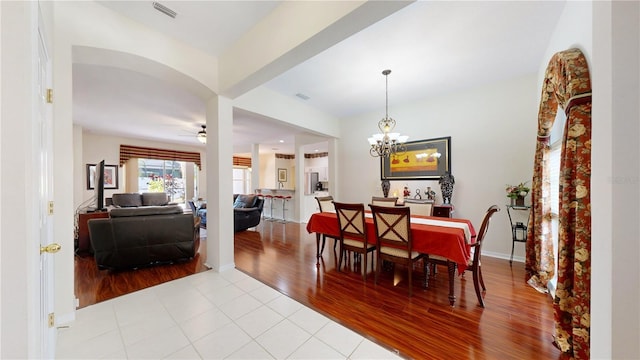 dining room with ceiling fan with notable chandelier and light tile patterned flooring