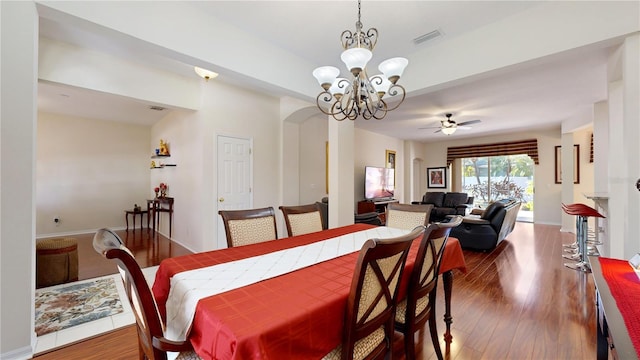 dining area featuring dark hardwood / wood-style floors and ceiling fan with notable chandelier