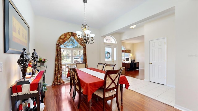 dining room with light wood-type flooring and a notable chandelier