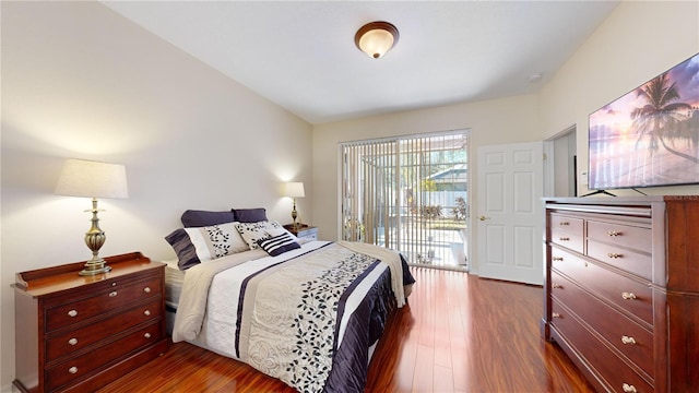 bedroom with access to exterior and dark wood-type flooring