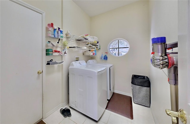 laundry area featuring washing machine and clothes dryer and light tile patterned floors