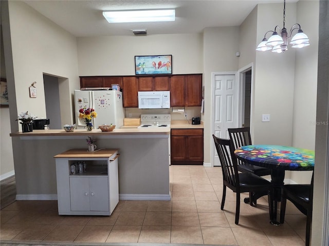 kitchen featuring a chandelier, pendant lighting, white appliances, and light tile patterned floors