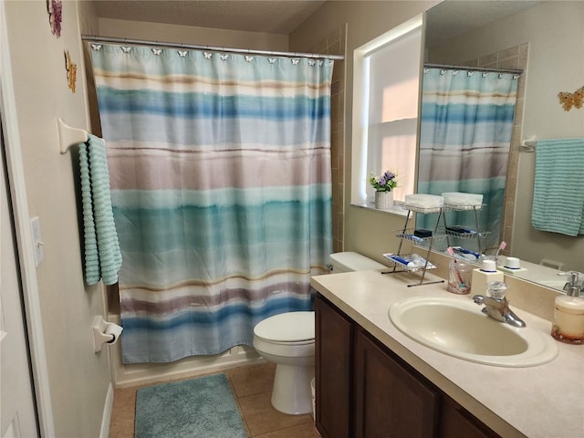 full bathroom featuring tile patterned flooring, vanity, toilet, and shower / bath combo with shower curtain