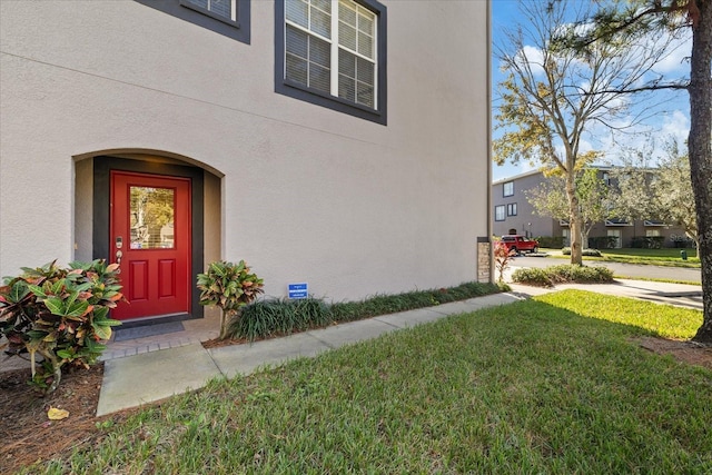 doorway to property featuring a yard