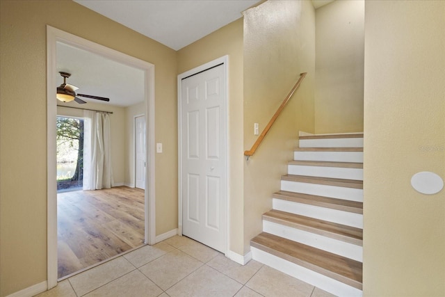 staircase featuring ceiling fan and tile patterned flooring