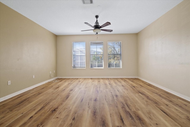 empty room with light hardwood / wood-style flooring and ceiling fan