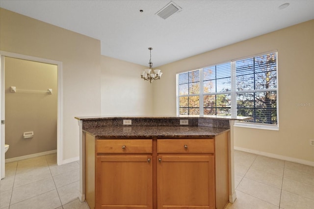 kitchen with a center island, a healthy amount of sunlight, and dark stone countertops