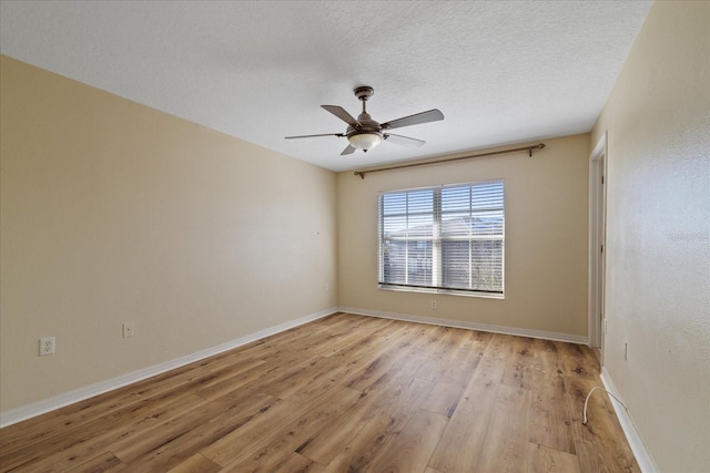 unfurnished room with a textured ceiling, light wood-type flooring, and ceiling fan