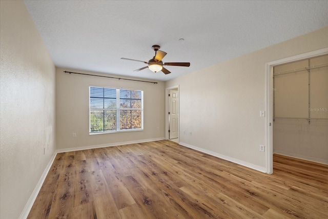 empty room featuring ceiling fan, light hardwood / wood-style floors, and a textured ceiling