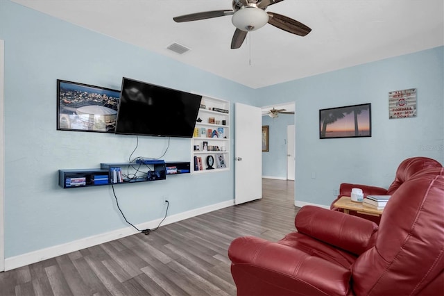 living room featuring built in shelves and hardwood / wood-style floors