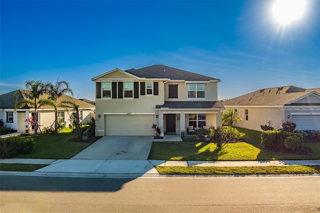 view of property with a front lawn and a garage